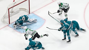 Feb 8, 2025; San Jose, California, USA; Dallas Stars center Colin Blackwell (15) looks on as center Wyatt Johnston (53) shoots the puck against San Jose Sharks goaltender Vitek Vanecek (41), defenseman Henry Thrun (3), and centers Will Smith (2) and Andrew Poturalski (22) during the third period at SAP Center at San Jose. Mandatory Credit: Robert Edwards-Imagn Images