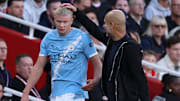 Erling Haaland (left) consults with Pep Guardiola (right) after being substituted.
