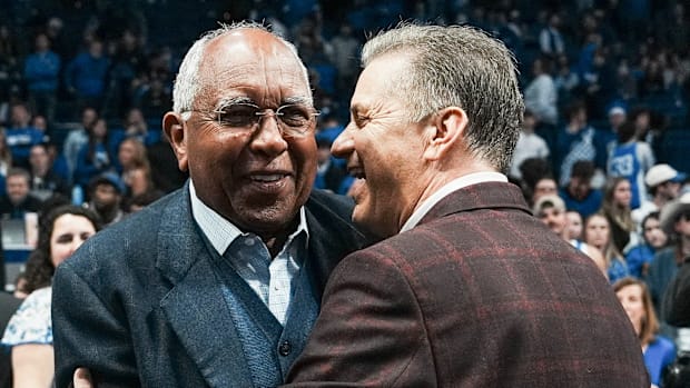 Arkansas coach John Calipari hugs fellow former Kentucky coach Tubby Smith after Calipari guided the Hogs to an 89-79 win 