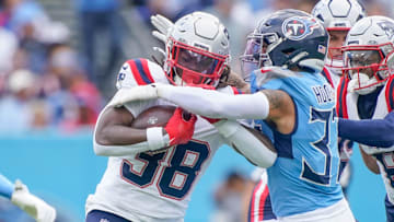 New England Patriots running back Rhamondre Stevenson (38) is stopped by Tennessee Titans safety Amani Hooker (37) during the first quarter at Nissan Stadium in Nashville, Tenn., Sunday, Oct. 19, 2025.