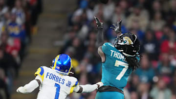 Oct 19, 2025; London, United Kingdom; Jacksonville Jaguars wide receiver Brian Thomas Jr. (7) reaches for the ball against Los Angeles Rams cornerback Emmanuel Forbes Jr. (1) during the second half of an NFL International Series game at Wembley Stadium. 