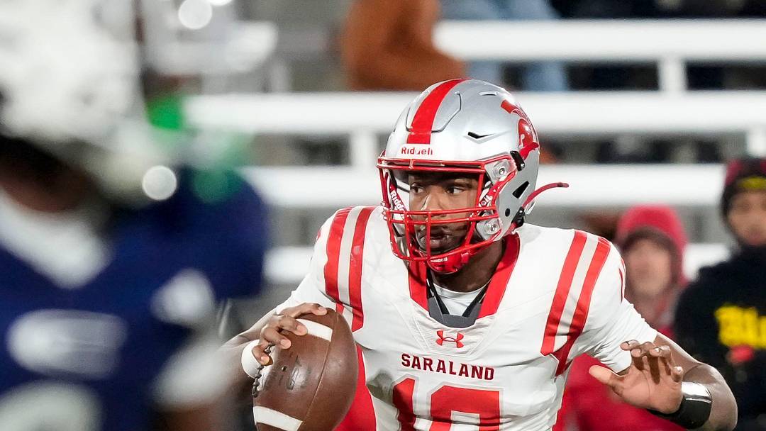 Saraland's Jamison Roberts (10) escapes a pass rush to throw a touchdown pass at the end of the first half against Clay-Chalkville at Protective Life Stadium in the AHSAA 6A State Championship game.