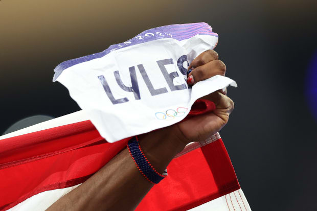 With an American flag draped on his shoulders, Lyles embraced his mom and other relatives after the race.