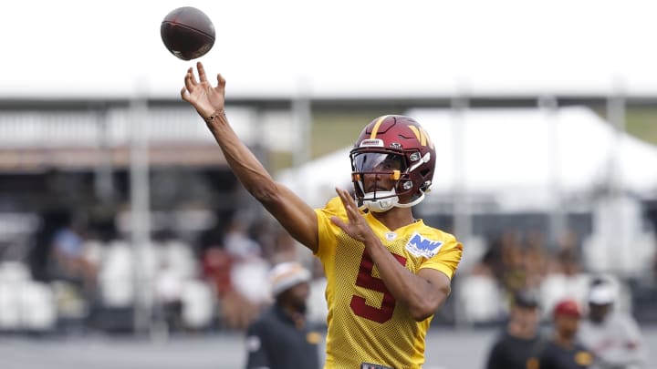 Jul 26, 2024; Ashburn, VA, USA; Washington Commanders quarterback Jayden Daniels (5) passes the ball on day three of training camp at Commanders Park. Mandatory Credit: Geoff Burke-USA TODAY Sports