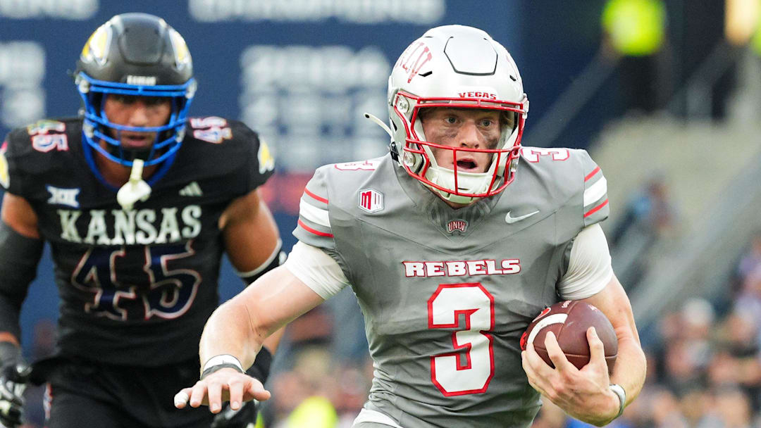 Sep 13, 2024; Kansas City, Kansas, USA; UNLV Rebels quarterback Matthew Sluka (3) runs the ball against Kansas Jayhawks defensive end Dean Miller (45) and cornerback Cobee Bryant (2) during the first half at Children's Mercy Park