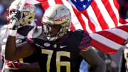 Nov 6, 2021; Tallahassee, Florida, USA; Florida State Seminoles offensive lineman Darius Washington (76) carries the American flag onto the field before the game against the North Carolina State Wolfpack at Doak S. Campbell Stadium. Mandatory Credit: Melina Myers-USA TODAY Sports