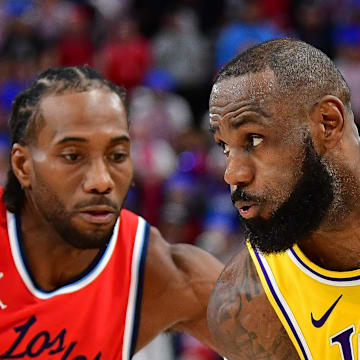 Feb 4, 2025; Inglewood, California, USA; Los Angeles Lakers forward LeBron James (23) moves the ball against Los Angeles Clippers forward Kawhi Leonard (2) during the second half at Intuit Dome. Mandatory Credit: Gary A. Vasquez-Imagn Images
