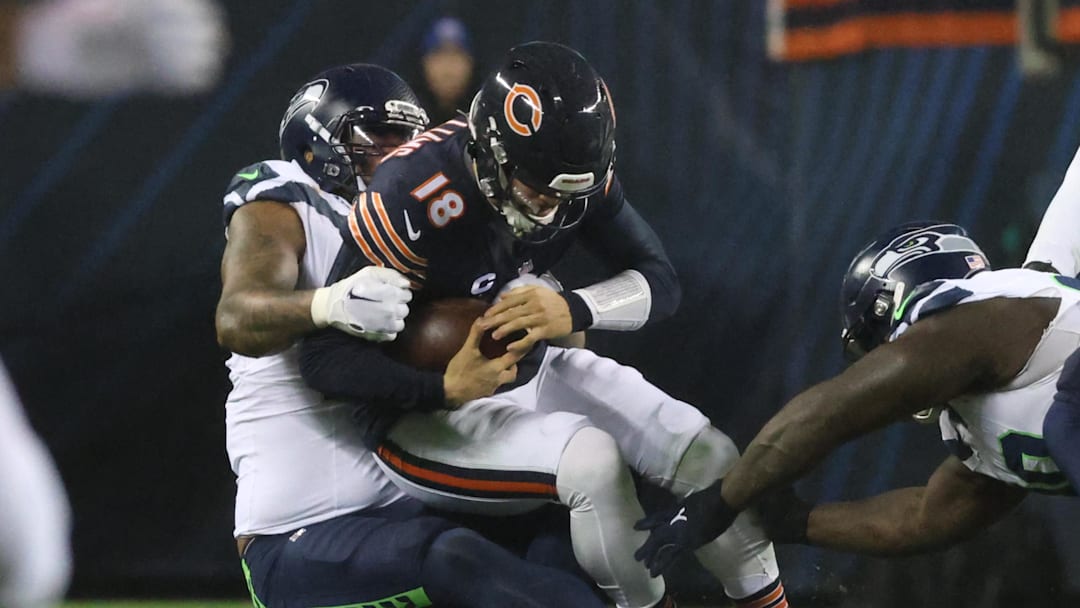 Dec 26, 2024; Chicago, Illinois, USA; Chicago Bears quarterback Caleb Williams (18) is sacked by Seattle Seahawks defensive end Leonard Williams (99) during the second quarter at Soldier Field. Mandatory Credit: Talia Sprague-Imagn Images