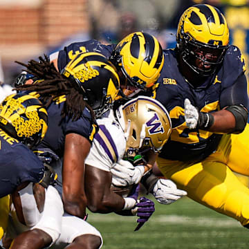 Michigan linebacker Jaishawn Barham (1) tackles Washington running back Adam Mohammed (24) during the first half at Michigan Stadium in Ann Arbor on Saturday, Oct. 18, 2025.