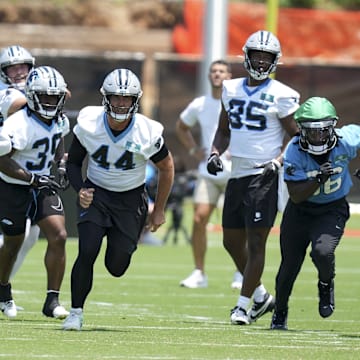 Jun 11, 2025; Charlotte, NC, USA; Carolina Panthers linebacker Nic Scourton (11), cornerback Mike Reid (35), long snapper JJ Jansen (44), tight end James Mitchell (85), safety Demani Richardson (36) and linebacker Christian Rozeboom (56) hustle to the ball during minicamp at Bank of America Stadium. 