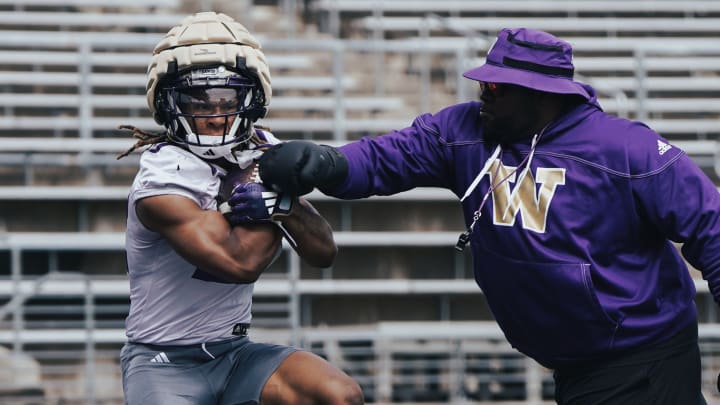 Cam Davis takes a ball punch from a UW staff member.