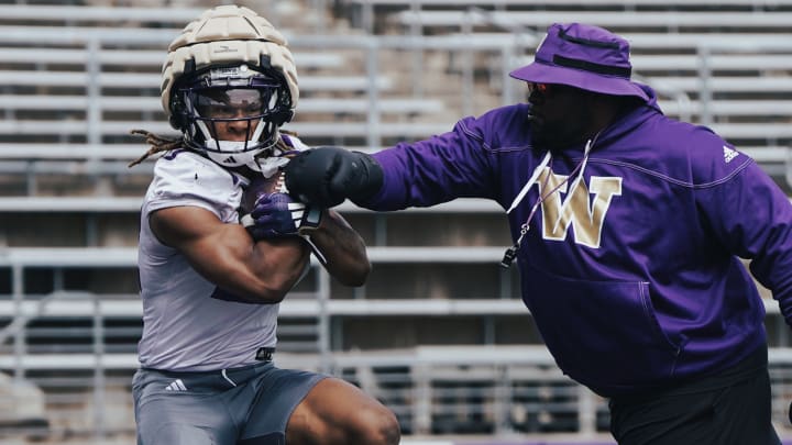 Cam Davis takes a ball punch from a UW staff member.