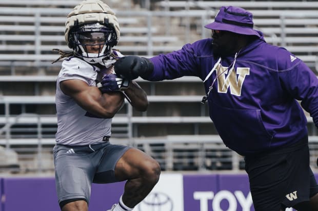 Cam Davis holds onto the ball while a coach tries separate him from it.