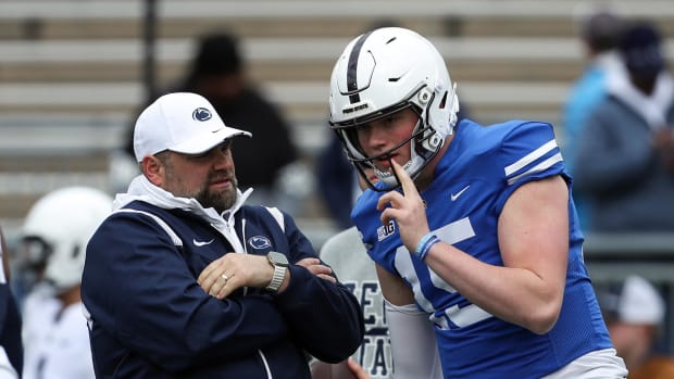 Penn State quarterback Drew Allar talks with offensive coordinator Andy Kotelnicki during a football game.