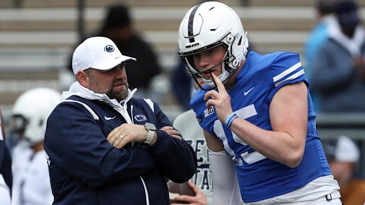 Penn State Nittany Lions quarterback Drew Allar (14) listens to offensive coordinator Andy Kotelnicki (left) 