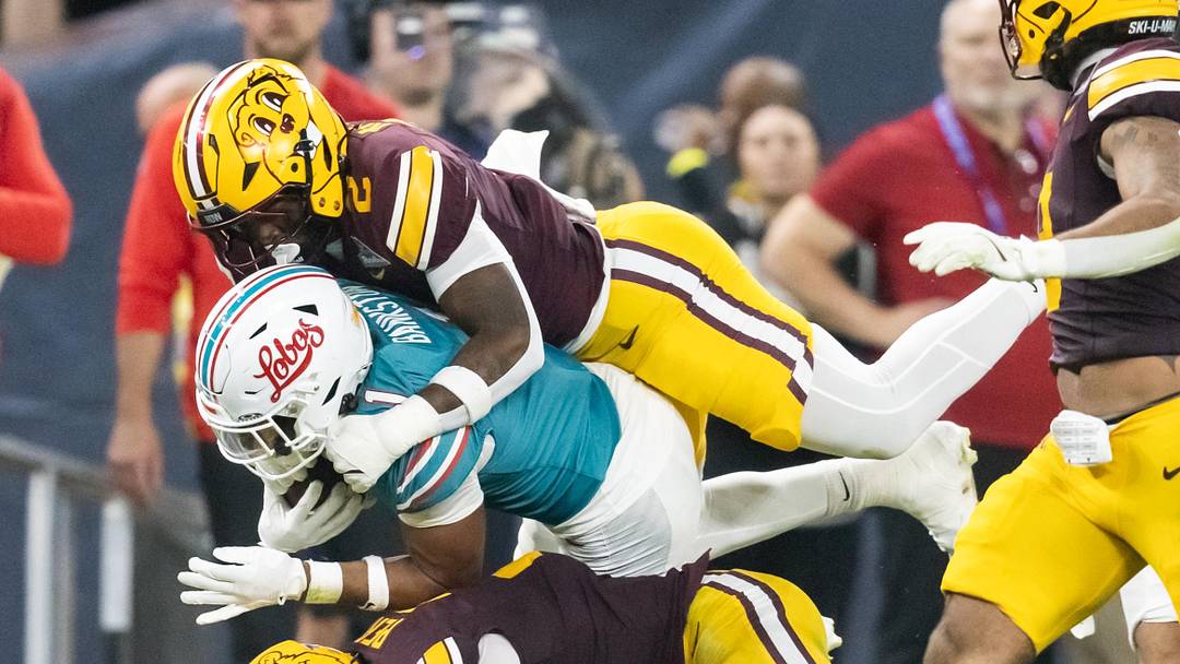 Dec 26, 2025; Phoenix, AZ, USA; New Mexico Lobos running back Damon Bankston (1) is tackled by Minnesota Gophers linebacker Emmanuel Karmo (2) and defensive back Koi Perich (3) during the first half of the Rate Bowl at Chase Field. Mandatory Credit: Mark J. Rebilas-Imagn Images Dec 26, 2025; Phoenix, AZ, USA; New Mexico Lobos running back Damon Bankston (1) is tackled by Minnesota Gophers linebacker Emmanuel Karmo (2) and defensive back Koi Perich (3) during the first half of the Rate Bowl at Chase Field. Mandatory Credit: Mark J. Rebilas-Imagn Images