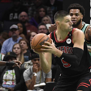 Dec 30, 2024; Charlotte, North Carolina, USA;  Chicago Bulls center Nikola Vucevic (9) looks to pass as he is guarded by Charlotte Hornets forward Miles Bridges (0) during the first half at the Spectrum Center. Mandatory Credit: Sam Sharpe-Imagn Images