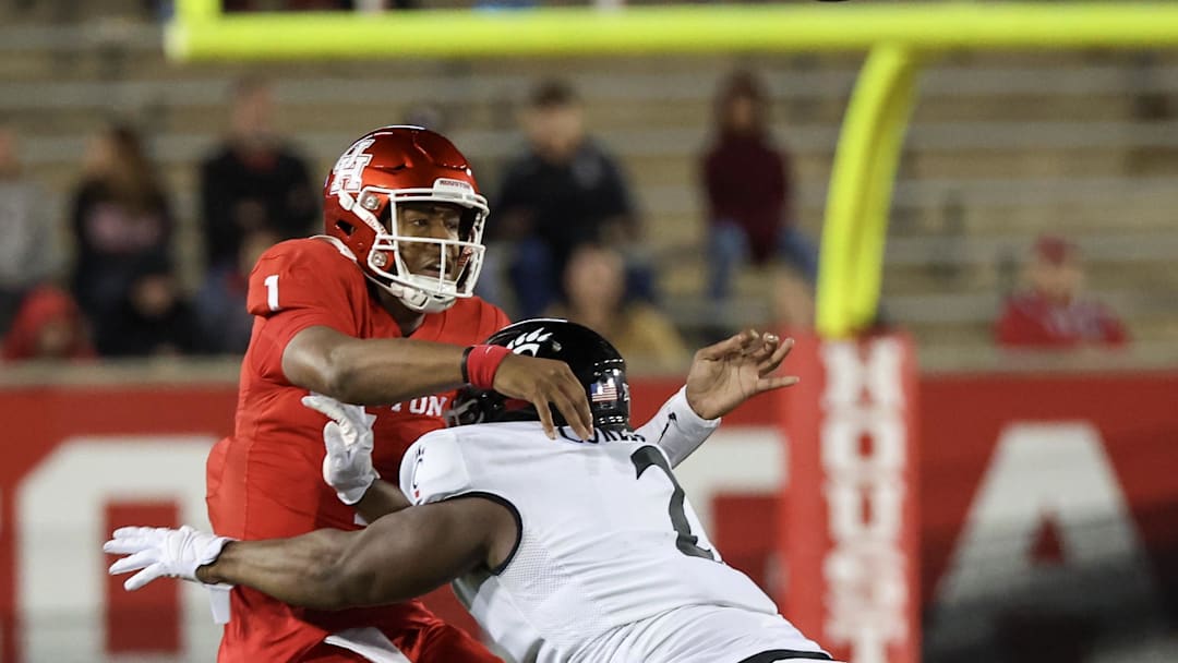Nov 11, 2023; Houston, Texas, USA; Houston Cougars quarterback Donovan Smith (1) passes the all while being hit by Cincinnati Bearcats defensive lineman Dontay Corleone (2) in the second half at TDECU Stadium. Mandatory Credit: Thomas Shea-Imagn Images