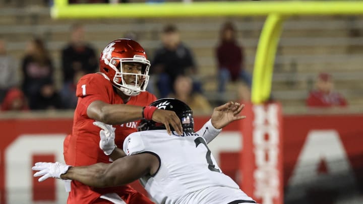 Nov 11, 2023; Houston, Texas, USA; Houston Cougars quarterback Donovan Smith (1) passes the all while being hit by Cincinnati Bearcats defensive lineman Dontay Corleone (2) in the second half at TDECU Stadium. Mandatory Credit: Thomas Shea-USA TODAY Sports