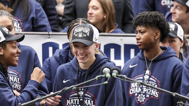 Apr 13, 2025; Hartford, CT, USA; UConn student-athlete Paige Bueckers approaches the podium to speak while teammates Ayanna Patterson and KK Arnold look on during the Final Four champions victory parade and rally outside of the XL Center in Hartford, CT. Mandatory Credit: Scott Rausenberger-Imagn Images Apr 13, 2025; Hartford, CT, USA; UConn student-athlete Paige Bueckers approaches the podium to speak while teammates Ayanna Patterson and KK Arnold look on during the Final Four champions victory parade and rally outside of the XL Center in Hartford, CT. Mandatory Credit: Scott Rausenberger-Imagn Images
