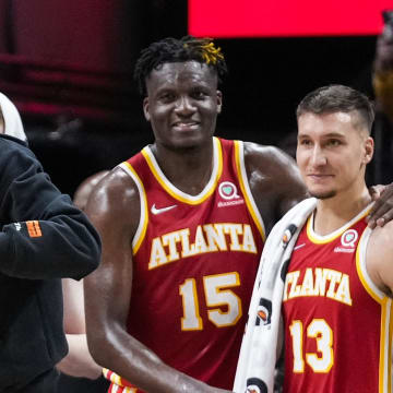 Mar 18, 2022; Atlanta, Georgia, USA; Atlanta Hawks forward John Collins center Clint Capela (15) and guards Bogdan Bogdanovic (13) and Trae Young (11) react after the Hawks defeated the  Memphis Grizzlies at State Farm Arena. Mandatory Credit: Dale Zanine-USA TODAY Sports