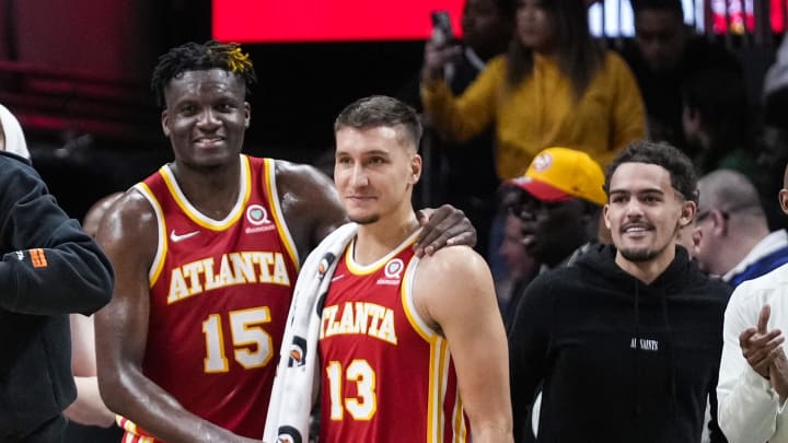 Mar 18, 2022; Atlanta, Georgia, USA; Atlanta Hawks forward John Collins center Clint Capela (15) and guards Bogdan Bogdanovic (13) and Trae Young (11) react after the Hawks defeated the  Memphis Grizzlies at State Farm Arena. Mandatory Credit: Dale Zanine-USA TODAY Sports