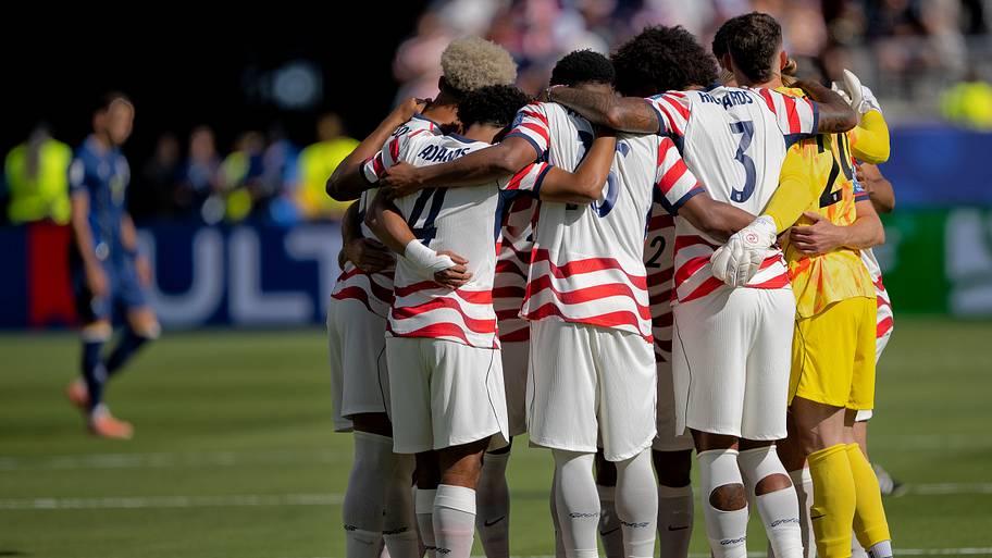 The USMNT players in a huddle.