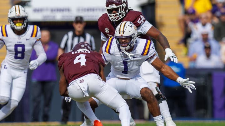 Nov 25, 2023; Baton Rouge, Louisiana, USA; Texas A&M Aggies running back Amari Daniels (4) is tacked by LSU Tigers linebacker Omar Speights (1) during the first half at Tiger Stadium. Mandatory Credit: Stephen Lew-USA TODAY Sports