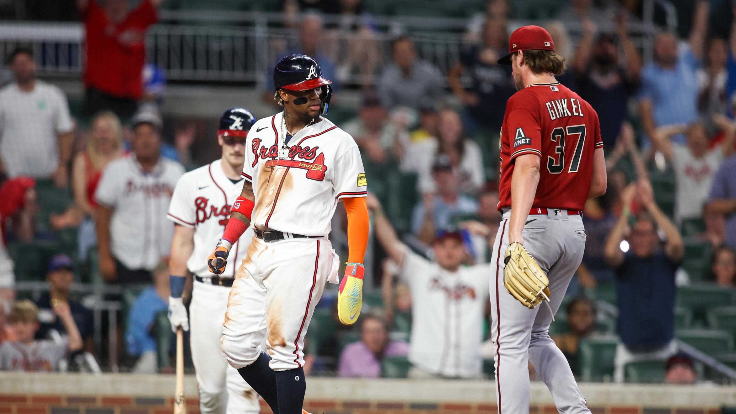 Braves right fielder Ronald Acuna Jr. (13) looks at Diamondbacks reliever Kevin Ginkel (37) after scoring a run.