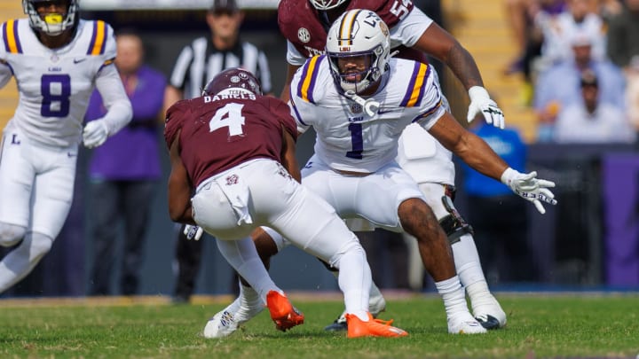 Nov 25, 2023; Baton Rouge, Louisiana, USA; Texas A&M Aggies running back Amari Daniels (4) is tacked by LSU Tigers linebacker Omar Speights (1) during the first half at Tiger Stadium. Mandatory Credit: Stephen Lew-USA TODAY Sports