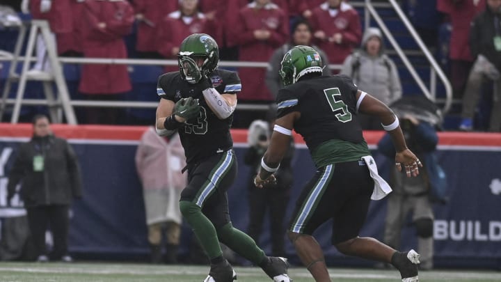 Dec 27, 2023; Annapolis, MD, USA;  Tulane Green Wave linebacker Tyler Grubbs (13) picks up a fumble for a touchdown during the first quarter against the Virginia Tech Hokies at Navy-Marine Corps Memorial Stadium.