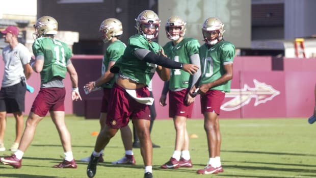 Florida State quarterbacks throw during practice on July 26, 2024.