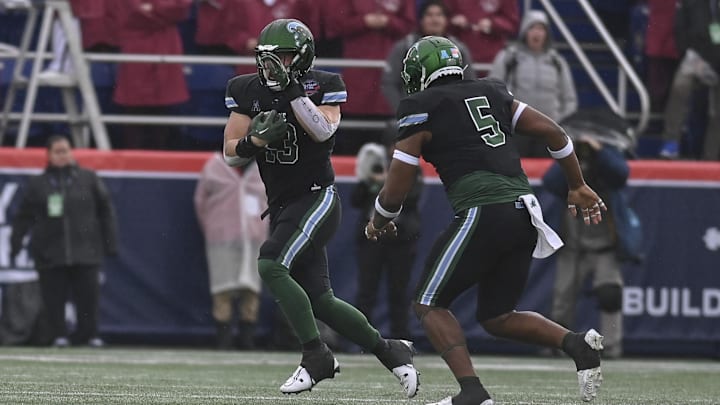 Dec 27, 2023; Annapolis, MD, USA;  Tulane Green Wave linebacker Tyler Grubbs (13) picks up a fumble for a touchdown during the first quarter against the Virginia Tech Hokies at Navy-Marine Corps Memorial Stadium. 