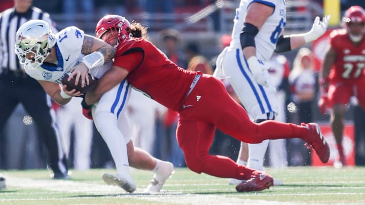 Louisville Cardinals defensive lineman Ashton Gillotte (9) brings down Kentucky Wildcats quarterback Devin Leary (13) for a sack in the first half Saturday. Nov. 25, 2023.