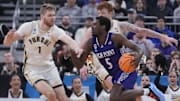 High Point Panthers forward Kimani Hamilton (5) dribbles the ball against Purdue Boilermakers forward Caleb Furst (1) and center Will Berg (44) during the first half at Amica Mutual Pavilion. 
