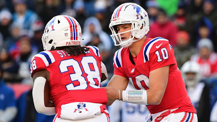 Dec 1, 2024; Foxborough, Massachusetts, USA;  New England Patriots quarterback Drake Maye (10) hands the ball off to running back Rhamondre Stevenson (38) during the first half against the Indianapolis Colts at Gillette Stadium. Mandatory Credit: Bob DeChiara-Imagn Images