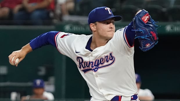 Texas Rangers pitcher Jack Leiter throws to the plate while wearing a white uniform and blue hat