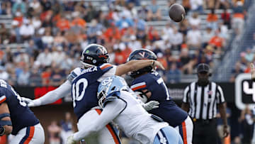 Oct 26, 2024; Charlottesville, Virginia, USA; Virginia Cavaliers quarterback Anthony Colandrea (10) passes the ball while being hit by North Carolina Tar Heels defensive end Kaimon Rucker (7) during the first half at Scott Stadium. Mandatory Credit: Geoff Burke-Imagn Images