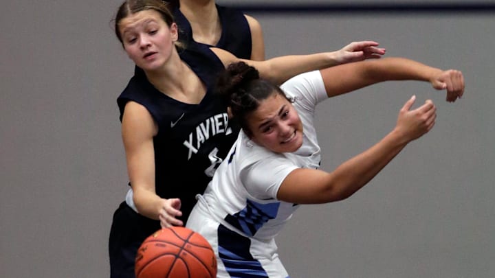 Xavier High School's Hailey Hafner (2) battles for a rebound against Menasha High School's Rayanna Jenkins (4) during their girls basketball game Thursday, December 11, 2025, in Menasha, Wisconsin. Xavier won 49-39. Xavier High School's Hailey Hafner (2) battles for a rebound against Menasha High School's Rayanna Jenkins (4) during their girls basketball game Thursday, December 11, 2025, in Menasha, Wisconsin. Xavier won 49-39.