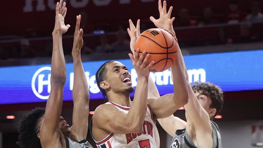 Feb 28, 2026; Houston, Texas, USA;  Houston Cougars guard Milos Uzan (7) splits the defense of Colorado Buffaloes guard Isaiah Johnson (2) and forward Sebastian Rancik (7) in the first half at Fertitta Center. 