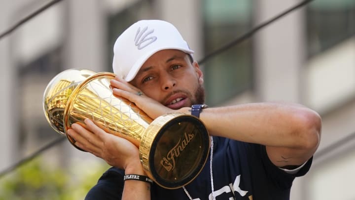 Jun 20, 2022; San Francisco, CA, USA; Golden State Warriors guard Stephen Curry poses with the NBA Finals Most Valuable Player Award trophy during the Warriors championship parade in downtown San Francisco. Mandatory Credit: Cary Edmondson-USA TODAY Sports