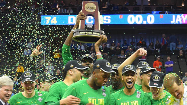Oregon Ducks players celebrate with the trophy after the game against the Kansas Jayhawks in the finals of the Midwest Region