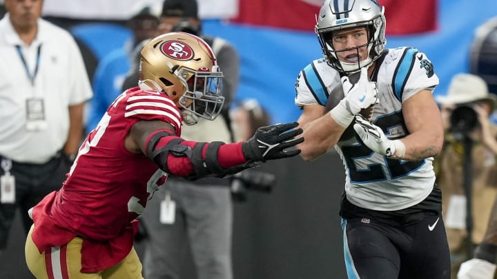 Oct 9, 2022; Charlotte, North Carolina, USA; Carolina Panthers running back Christian McCaffrey (22) tries to elude San Francisco 49ers defensive end Kemoko Turay (53) during the second half at Bank of America Stadium. Mandatory Credit: Jim Dedmon-USA TODAY Sports