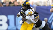 Dec 30, 2024; Nashville, TN, USA;  Iowa Hawkeye running back Jaziun Patterson (9) gets tackled from behind by Missouri Tigers defensive end Johnny Walker Jr. (15) during the first half at Nissan Stadium. Mandatory Credit: Steve Roberts-Imagn Images