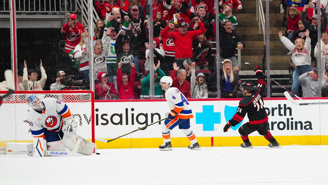 Mar 30, 2025; Raleigh, North Carolina, USA;  Carolina Hurricanes center Seth Jarvis (24) celebrates his goal past New York Islanders goaltender Marcus Hogberg (50) during the second period at Lenovo Center. Mandatory Credit: James Guillory-Imagn Images