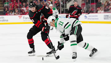 Nov 25, 2024; Raleigh, North Carolina, USA;  Dallas Stars center Logan Stankoven (11) and Carolina Hurricanes center Martin Necas (88) battle over the puck during the second period at Lenovo Center. Mandatory Credit: James Guillory-Imagn Images
