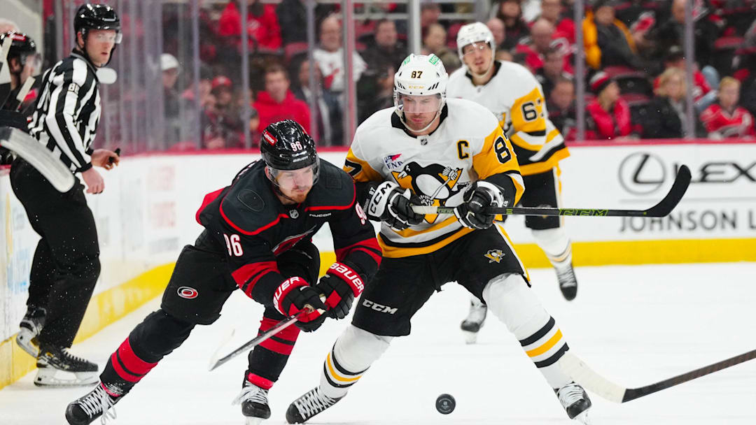 Jan 5, 2025; Raleigh, North Carolina, USA;  Carolina Hurricanes center Jack Roslovic (96) and Pittsburgh Penguins center Sidney Crosby (87) battle over the puck during the third period at Lenovo Center.