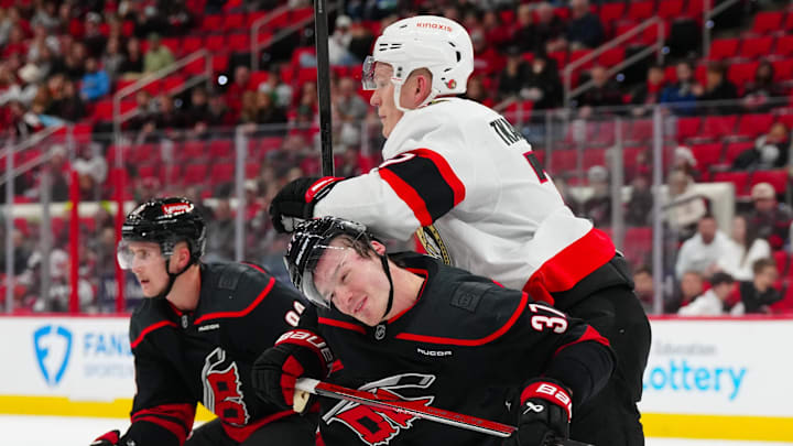 Dec 13, 2024; Raleigh, North Carolina, USA; Ottawa Senators left wing Brady Tkachuk (7) checks Carolina Hurricanes right wing Andrei Svechnikov (37) during the third period at Lenovo Center. Mandatory Credit: James Guillory-Imagn Images