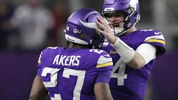 Dec 29, 2024; Minneapolis, Minnesota, USA; Minnesota Vikings quarterback Sam Darnold (14) celebrates a first down reception by running back Cam Akers (27) late in fourth quarter at U.S. Bank Stadium. Mandatory Credit: Dan Powers/USA TODAY NETWORK-Wisconsin via Imagn Images