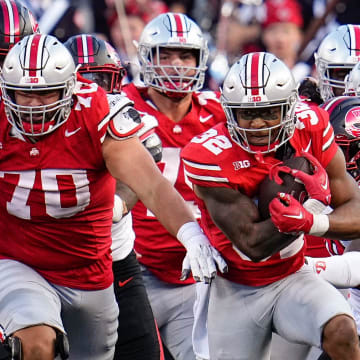 Sep 16, 2023; Columbus, Ohio, USA; Ohio State Buckeyes running back TreVeyon Henderson (32) gets a block from offensive lineman Josh Fryar (70) during the second half of the NCAA football game against the Western Kentucky Hilltoppers at Ohio Stadium. Ohio State won 63-10.